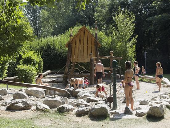 Kinderspielplatz im Familienbad Dachau, spielende Kinder vor Klettergerüst