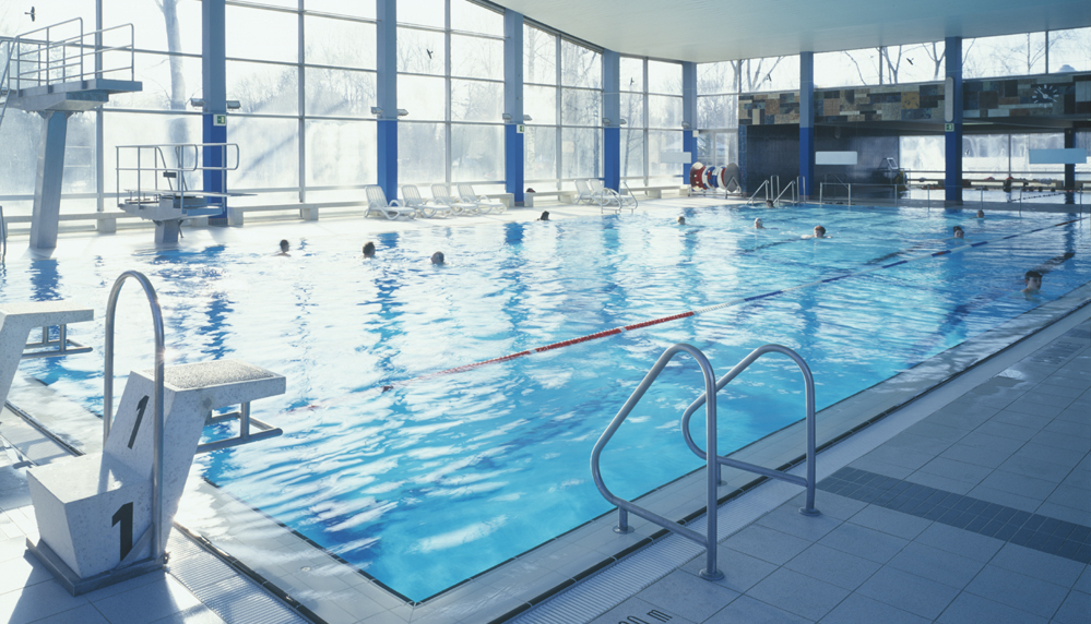 Blick auf das Schwimmbecken im Hallenbad Dachau, Startblock und Sprungturm