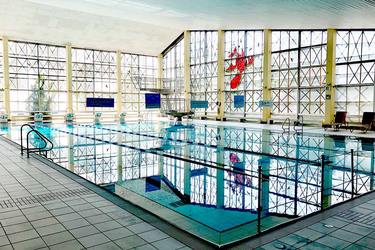 Schwimmbecken mit großer Glasfront im Hintergrund