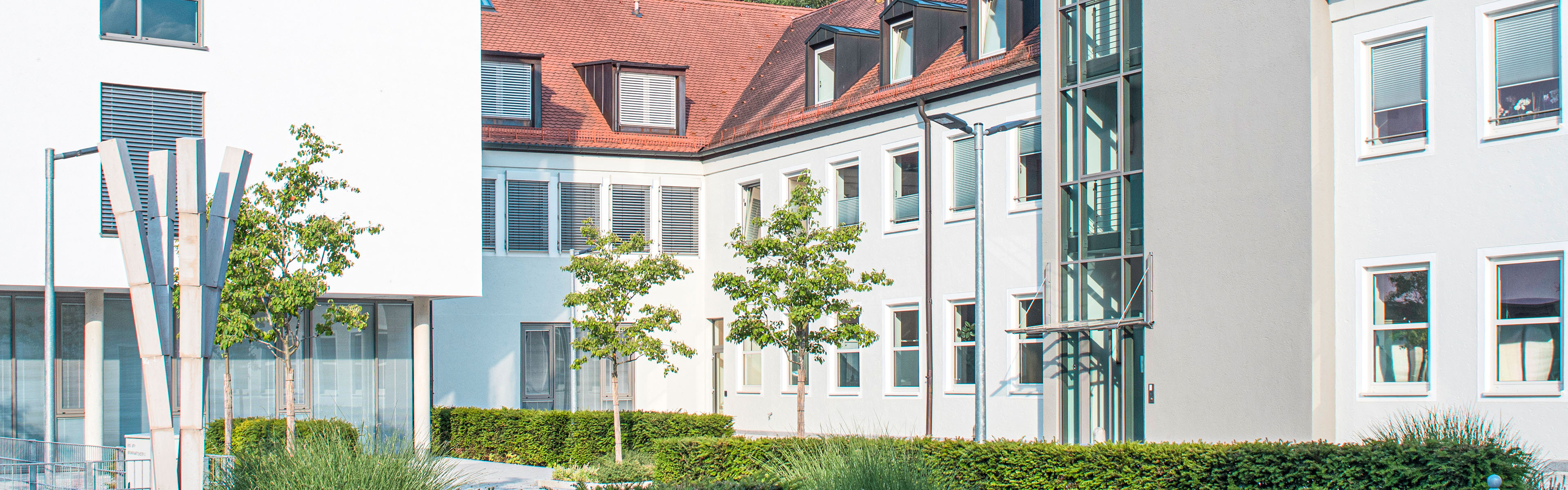 Innenhof des Gebäudes der Stadtwerke Dachau, Altbau und Neubau mit Bäumen im Hof