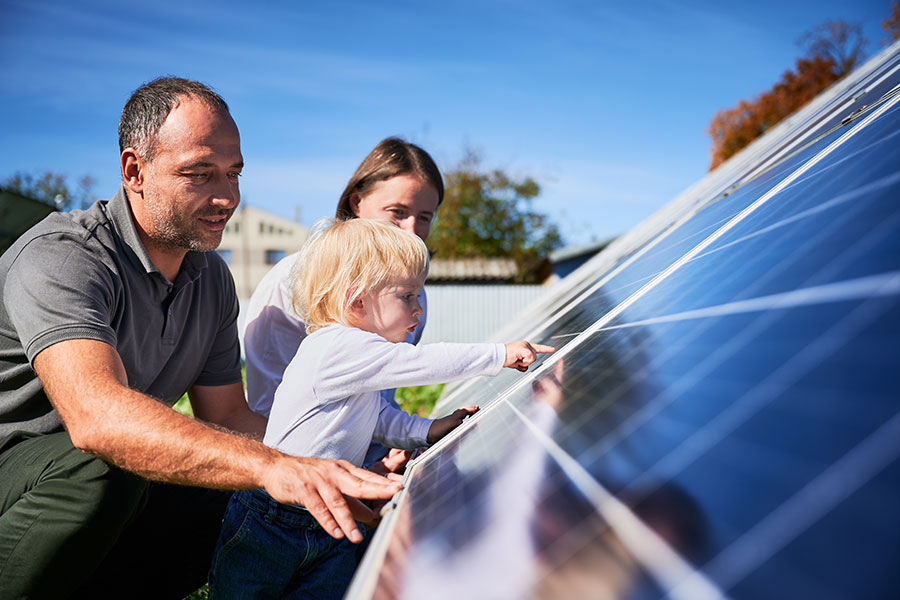 Familie mit Kind begutachten ein Solarmodul