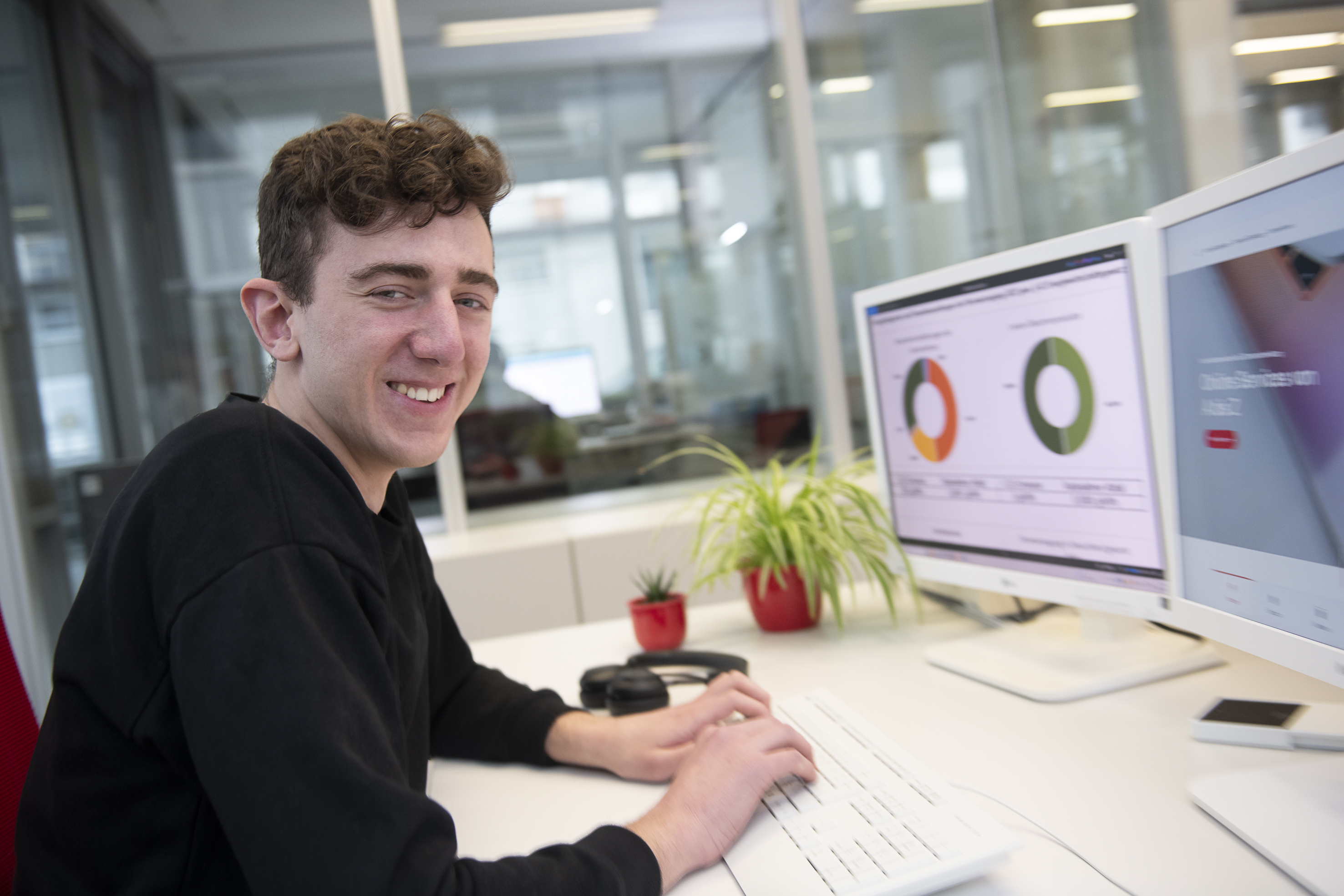 Industriekaufmann im Kundenservice bei der Arbeit am Schreibtisch – moderne Bürokommunikation und Kundenbetreuung in einem professionellen Umfeld.